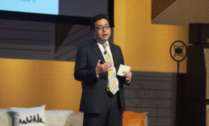 a ma wearing a suit giving a speech