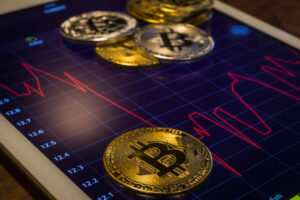 a tablet with bitcoins and a chart on it