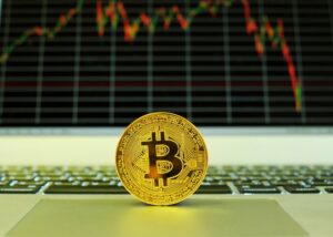 a bit coin sitting on top of a laptop computer