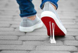 a person wearing blue jeans and grey sneakers