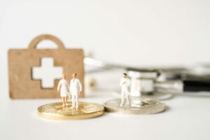 a couple of tiny figurines standing on top of a coin