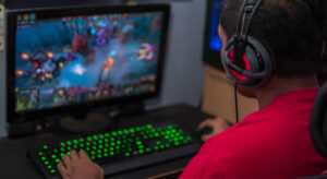 a man sitting in front of a computer with headphones on
