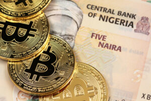 a pile of gold bitcoins sitting on top of a pile of money