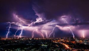 a bunch of lightning strikes over a city at night