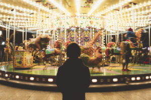 a man standing in front of a merry go round
