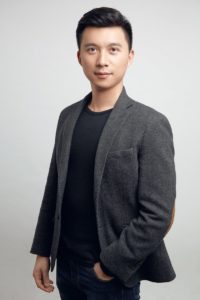 a man in a black shirt and a gray jacket