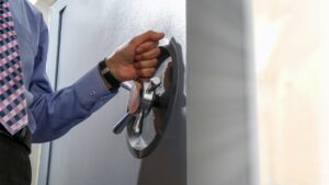 a man in a blue shirt and tie is opening a door