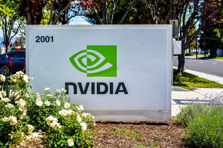 a sign for a company in front of some flowers