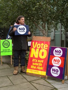 a man holding a sign that says vote no it's not worth the fish