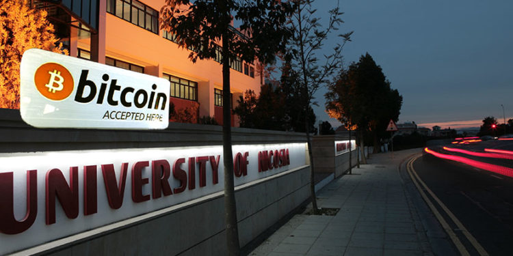 a lit up bitcoin sign on the side of a building