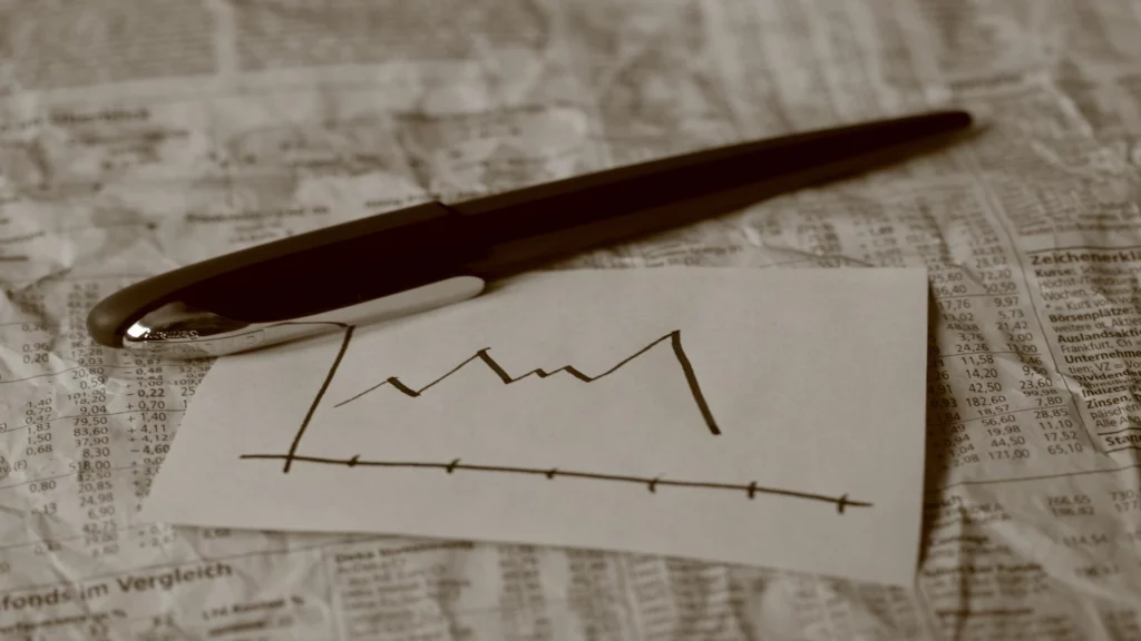 pen on paper showing price chart.