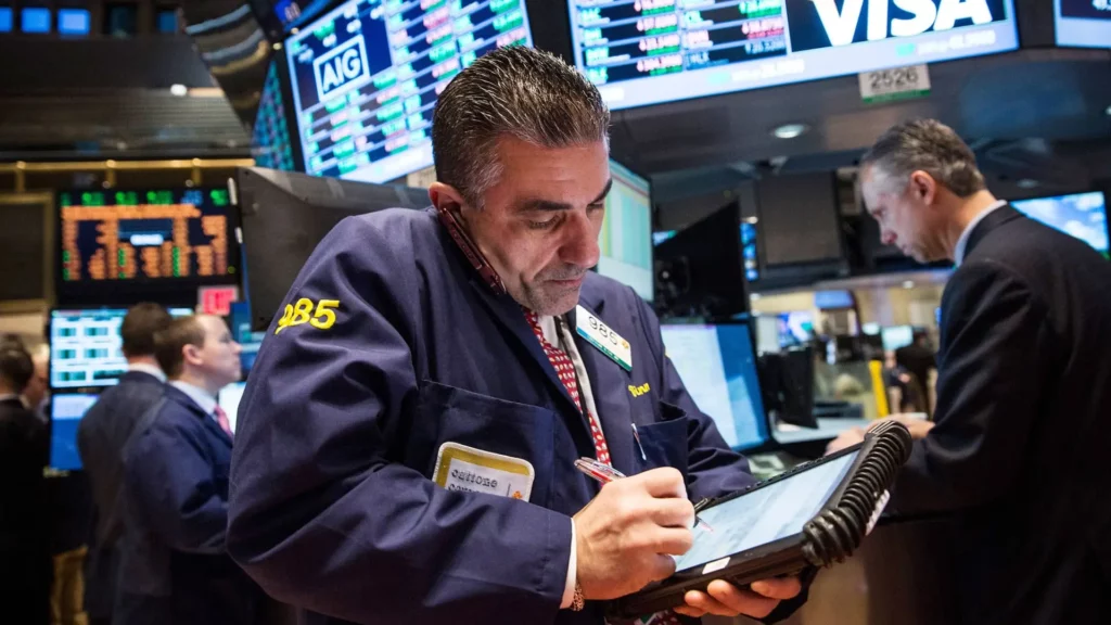 Wall Street stock trader on the telephphone holding tablet device.